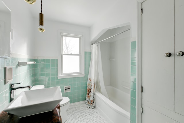 full bathroom featuring sink, tile patterned flooring, toilet, shower / bath combo with shower curtain, and tile walls