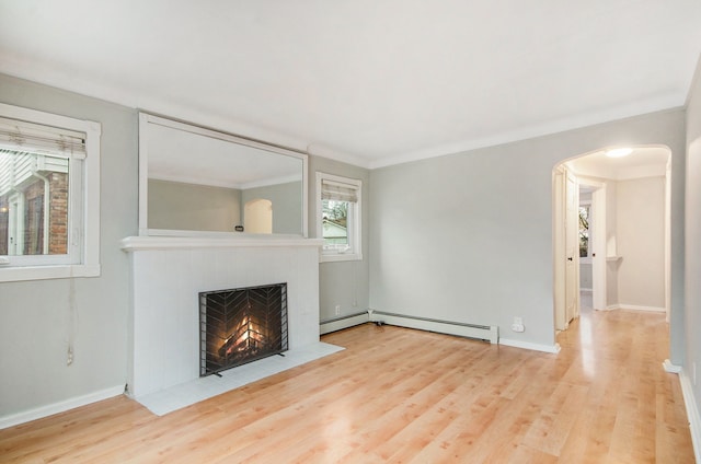 unfurnished living room featuring light hardwood / wood-style floors, crown molding, and a baseboard heating unit