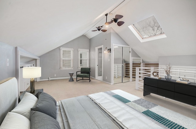 carpeted bedroom featuring lofted ceiling with skylight and ceiling fan