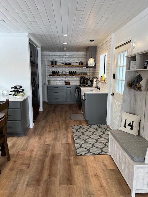 kitchen with gray cabinetry, dark hardwood / wood-style flooring, wooden ceiling, and decorative light fixtures