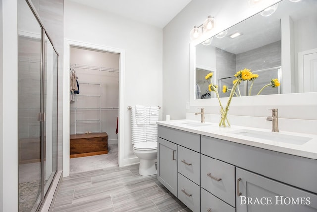 bathroom with vanity, toilet, and an enclosed shower