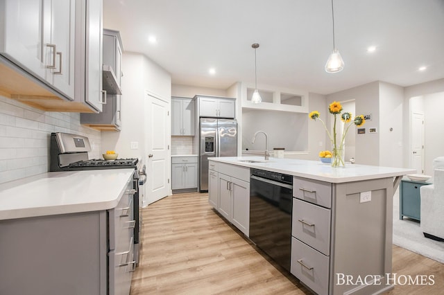 kitchen with gray cabinets, a kitchen island with sink, hanging light fixtures, and appliances with stainless steel finishes