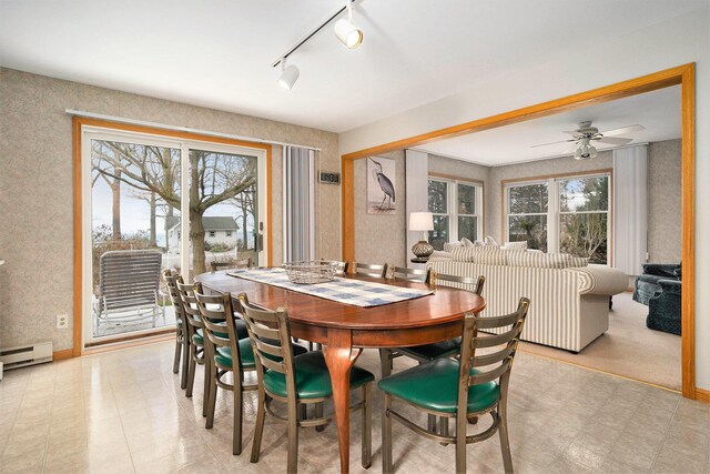 dining space featuring a wealth of natural light, a baseboard heating unit, and ceiling fan