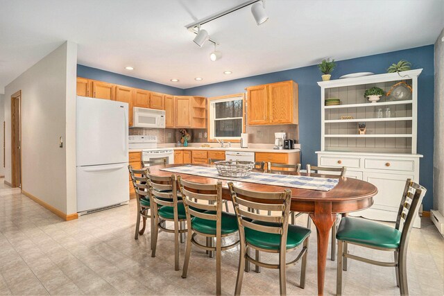 kitchen with light brown cabinets, white appliances, tasteful backsplash, and sink