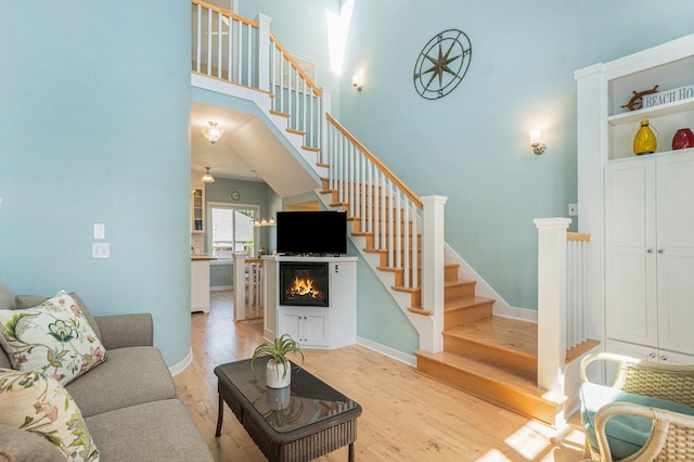 living room with a high ceiling and light hardwood / wood-style flooring