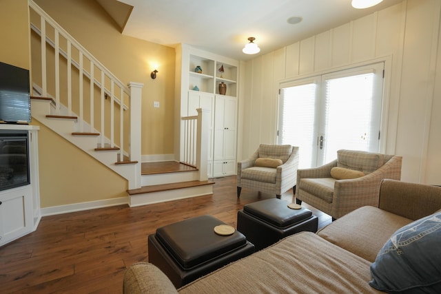 living room featuring built in features and dark wood-type flooring