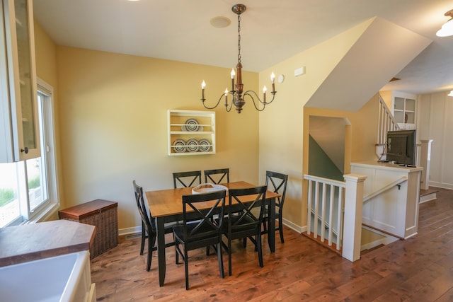 dining area with dark hardwood / wood-style floors and an inviting chandelier