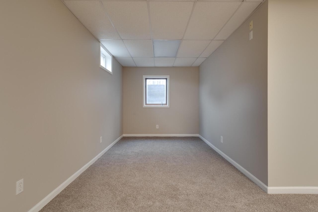 empty room with light colored carpet and a drop ceiling