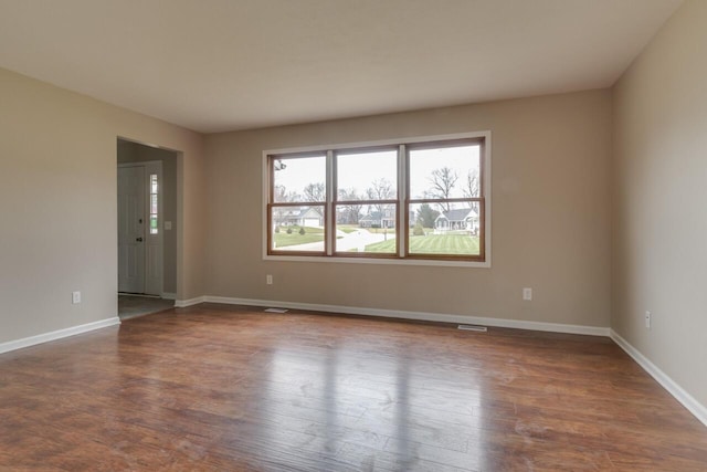 empty room with dark hardwood / wood-style flooring