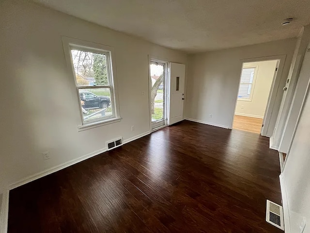 spare room with dark wood-type flooring