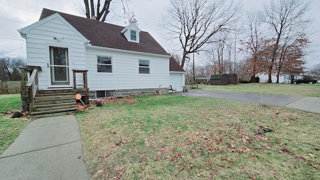 view of front of house with an outdoor structure and a front lawn