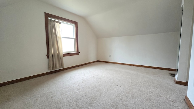 bonus room with carpet flooring and vaulted ceiling