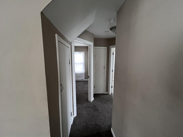 hallway with dark colored carpet