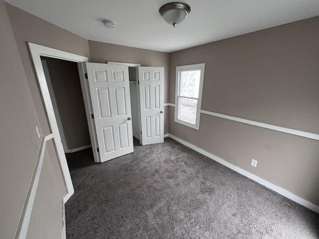 unfurnished bedroom featuring dark carpet