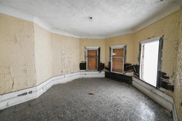 unfurnished room featuring lofted ceiling and a textured ceiling