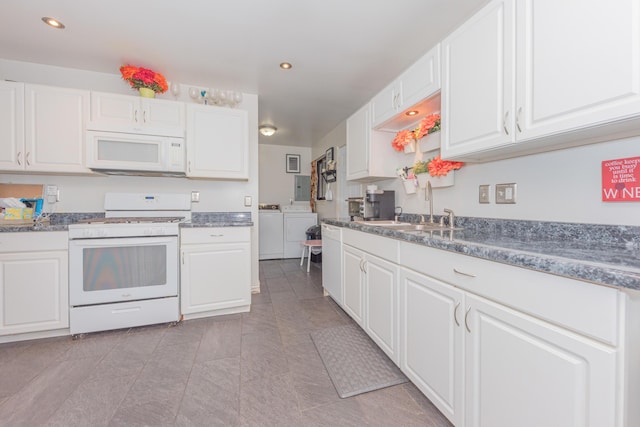 kitchen featuring sink, white cabinets, washer and dryer, and white appliances