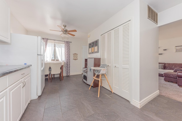 kitchen with ceiling fan, white cabinets, and white fridge