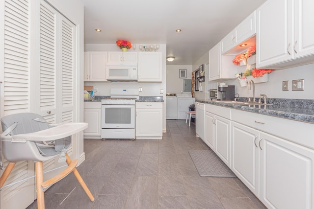 kitchen with separate washer and dryer, white cabinetry, sink, and white appliances