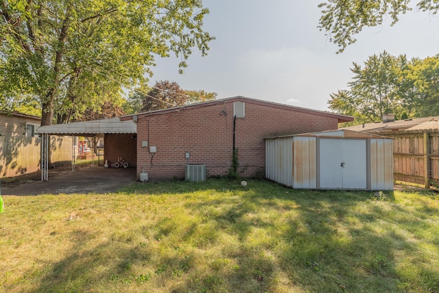 exterior space with a carport, central AC unit, a shed, and a yard