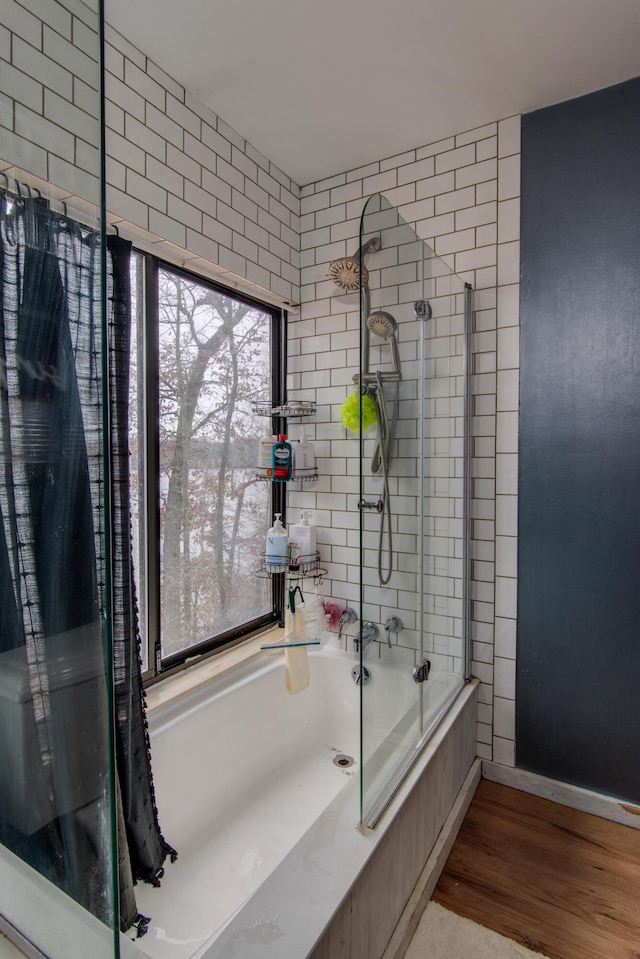 bathroom with combined bath / shower with glass door and wood finished floors