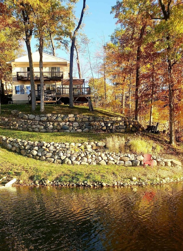 back of property with a deck with water view