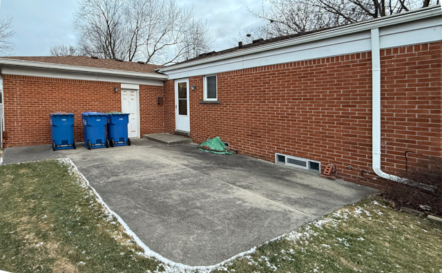 view of side of property with a patio area and brick siding