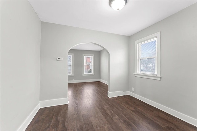 spare room featuring dark hardwood / wood-style flooring and plenty of natural light