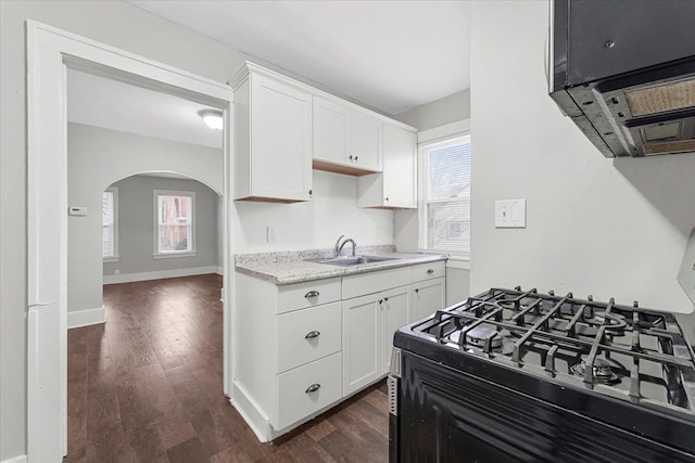 kitchen featuring sink, white cabinets, dark wood-type flooring, and stove