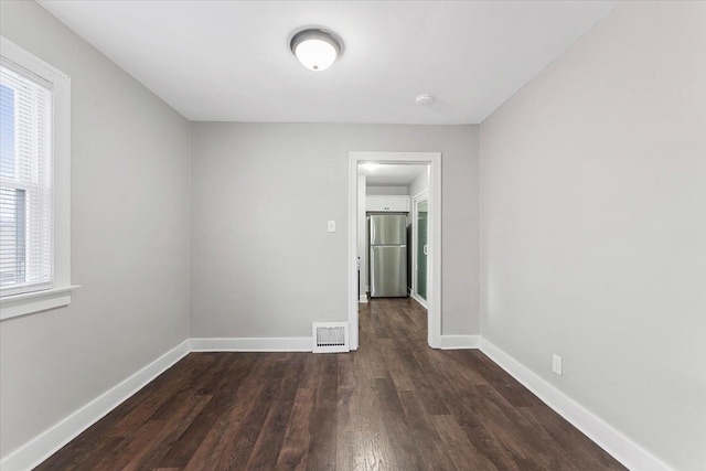 unfurnished room with dark wood-type flooring