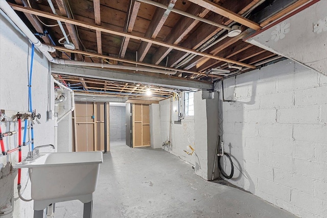 basement featuring electric panel and sink