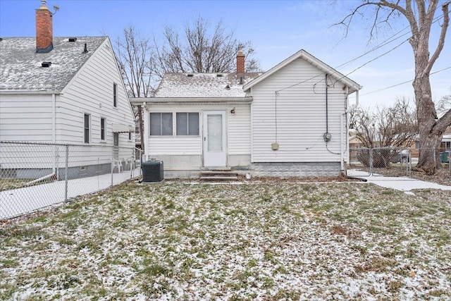 snow covered property featuring central AC and a yard