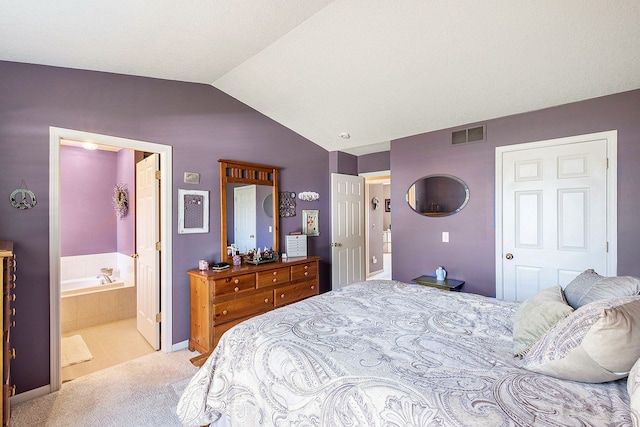 carpeted bedroom with ensuite bathroom, a closet, and vaulted ceiling