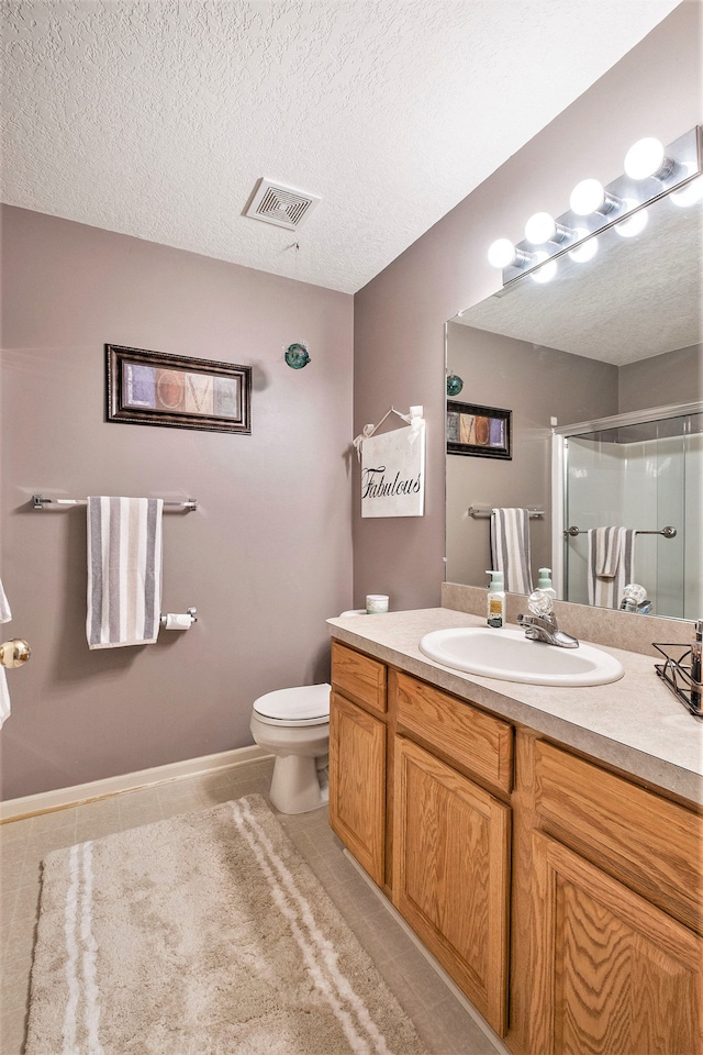 bathroom featuring tile patterned floors, vanity, a textured ceiling, and walk in shower