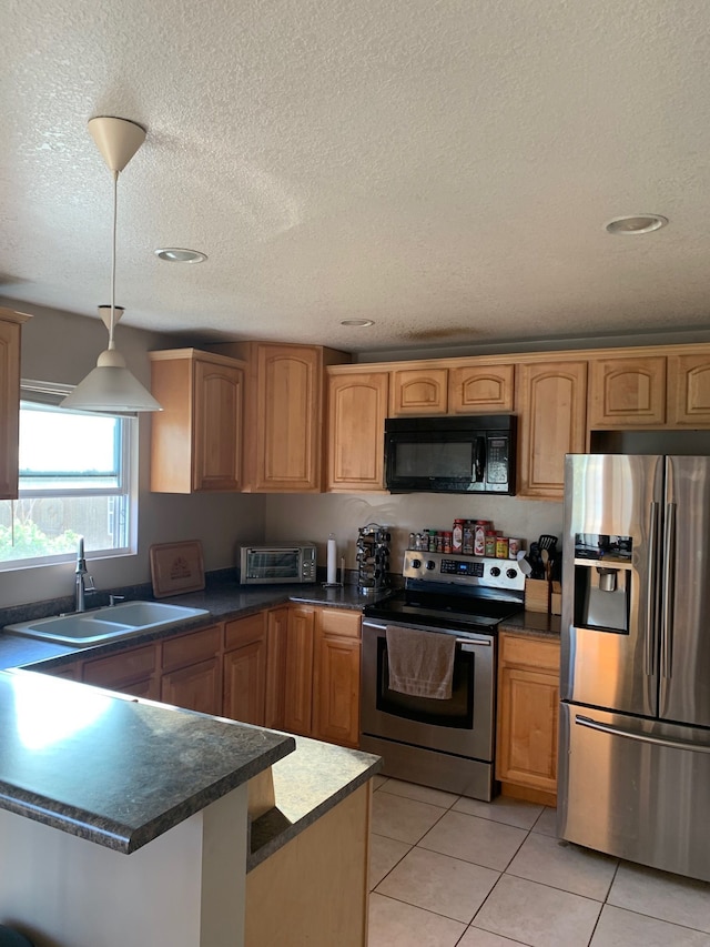 kitchen with sink, hanging light fixtures, a textured ceiling, light tile patterned flooring, and appliances with stainless steel finishes