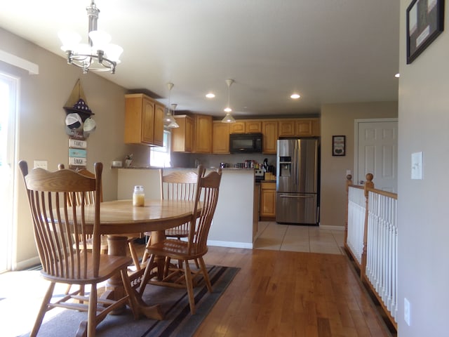 dining area featuring light wood-type flooring and a notable chandelier