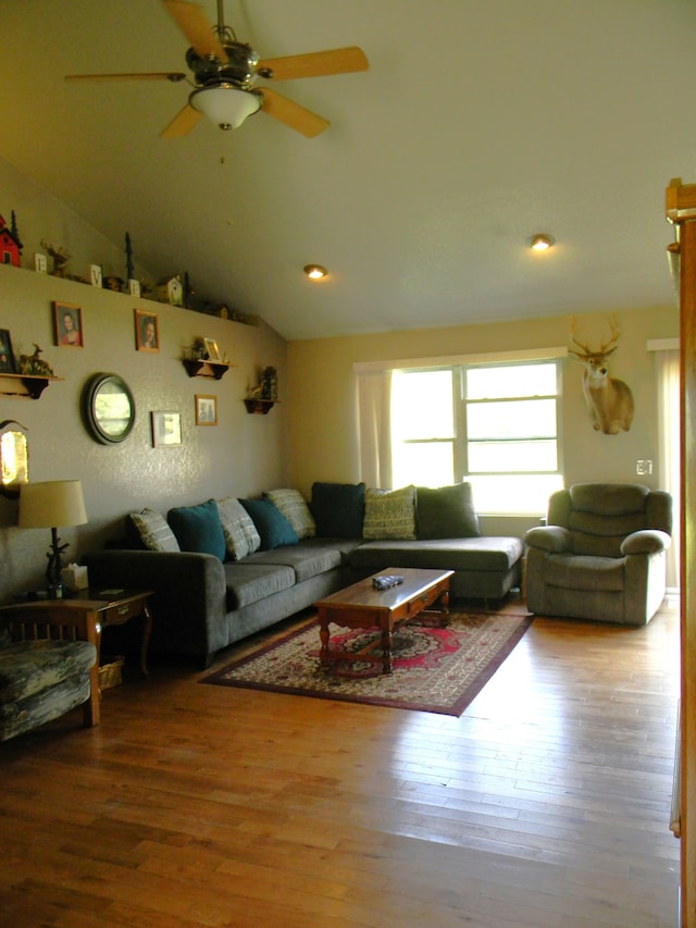 living room featuring hardwood / wood-style floors, ceiling fan, and lofted ceiling