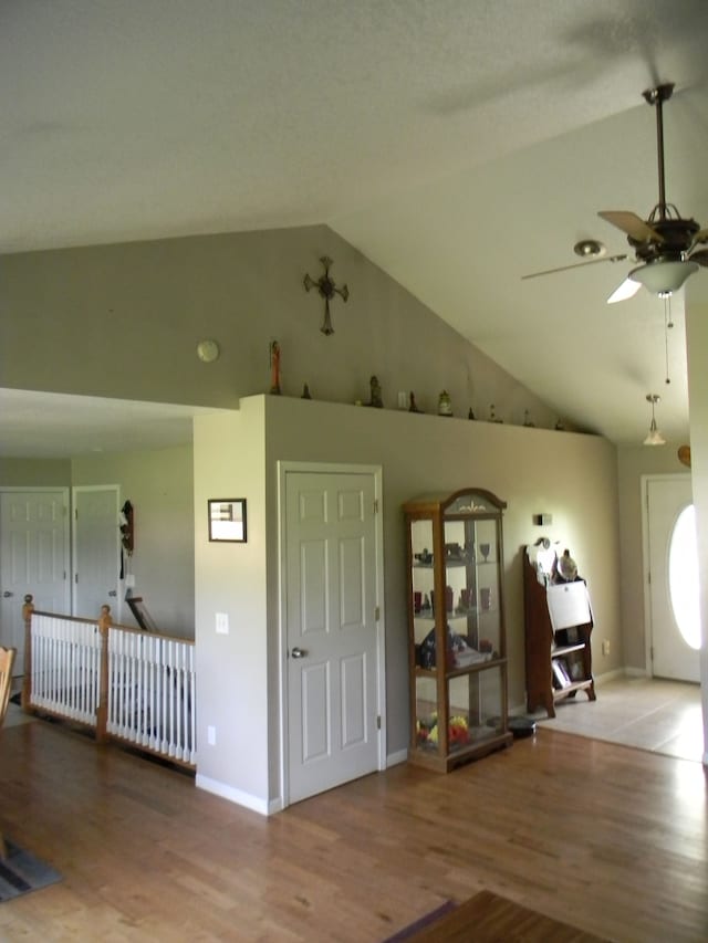 foyer with ceiling fan, hardwood / wood-style floors, and high vaulted ceiling