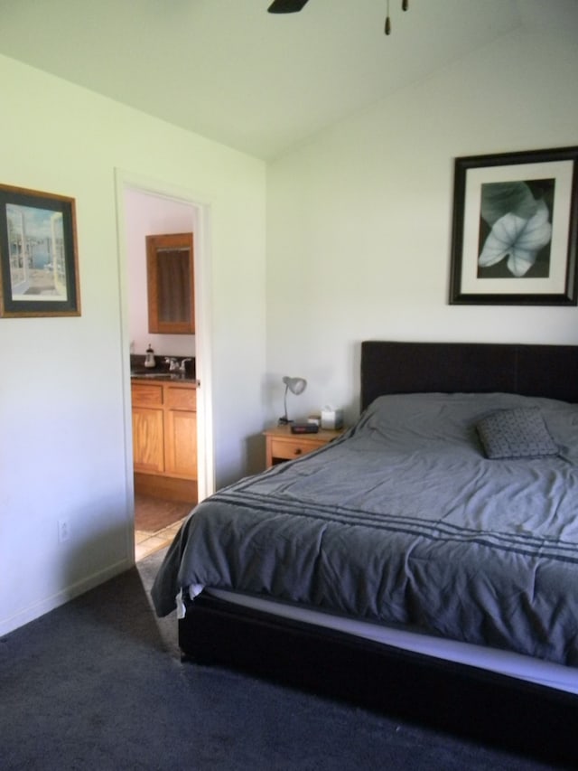 bedroom with ceiling fan, carpet floors, connected bathroom, and lofted ceiling