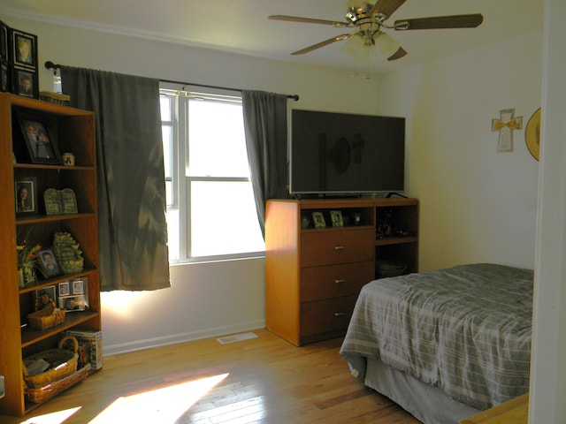 bedroom featuring multiple windows, light hardwood / wood-style floors, and ceiling fan