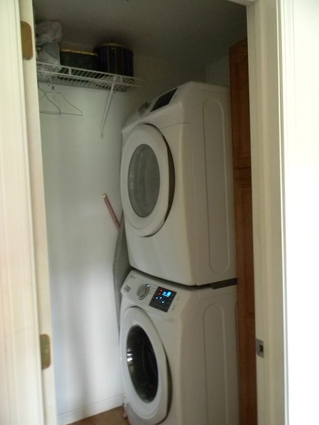 laundry area featuring cabinets and stacked washer and dryer