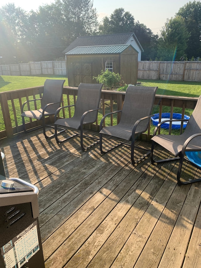 deck with a lawn and a storage shed