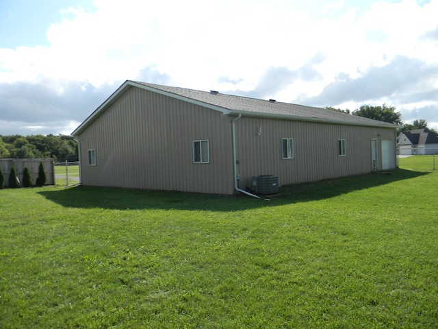 view of side of property featuring a lawn and cooling unit