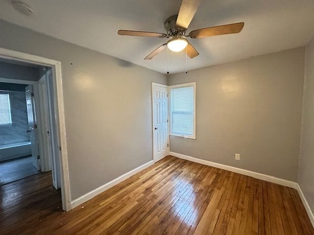 unfurnished bedroom with dark hardwood / wood-style floors, ceiling fan, and a closet