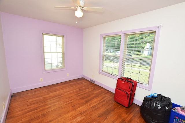 empty room with ceiling fan and dark wood-type flooring