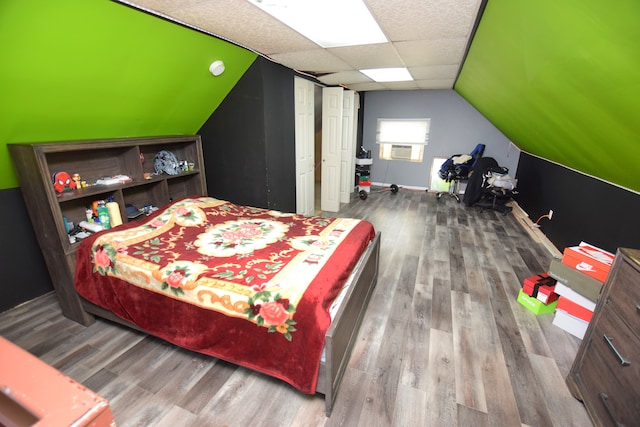 bedroom with hardwood / wood-style floors and lofted ceiling