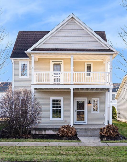 view of front of house with a balcony and a front lawn