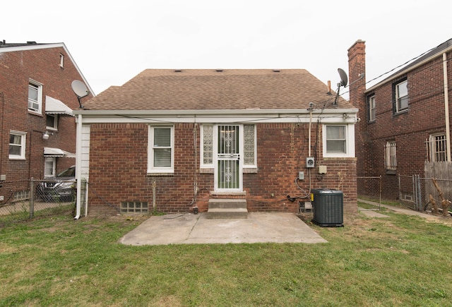 rear view of house featuring central AC unit, a yard, and a patio