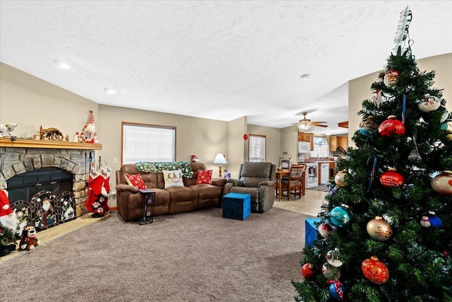 living room with carpet, a textured ceiling, and a stone fireplace