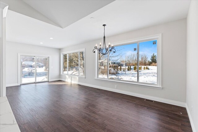 unfurnished dining area featuring an inviting chandelier, baseboards, visible vents, and dark wood-type flooring