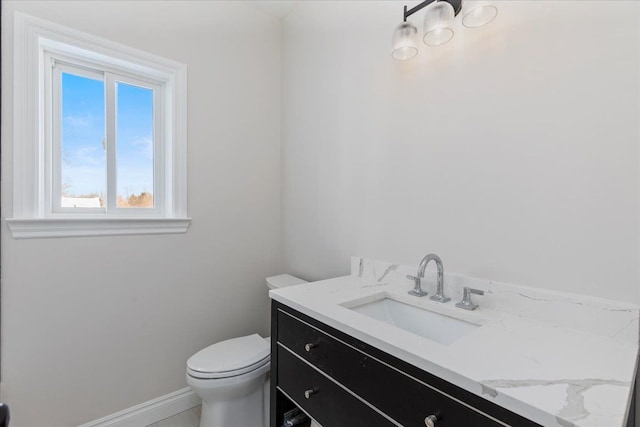 bathroom featuring baseboards, vanity, and toilet